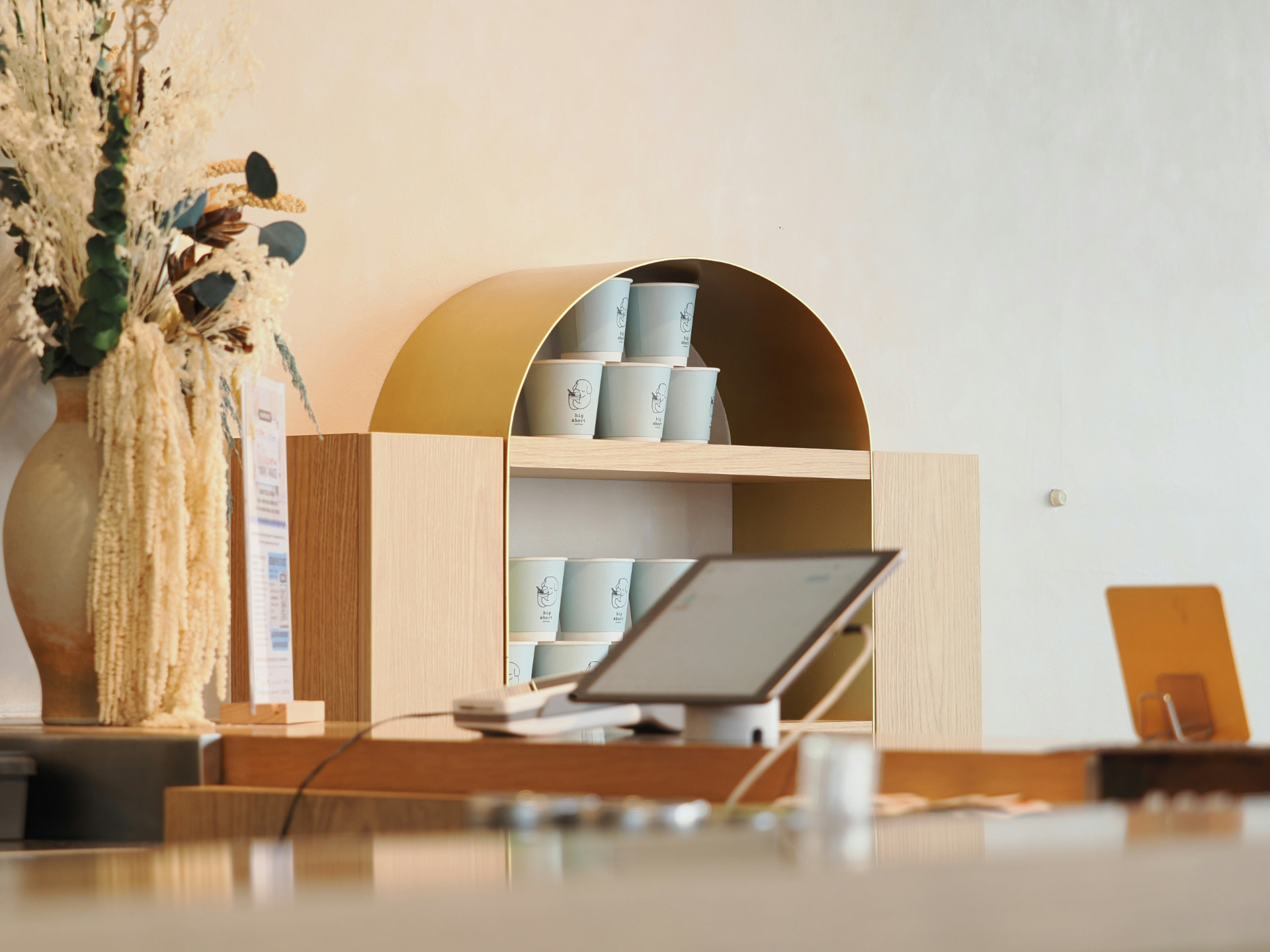 Warm minimalist interior with a brass arch and soft daylight — the Laser & Light room headline